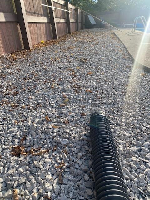Black pipe draining into gravel